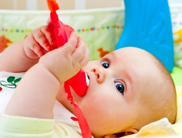 Little baby girl playing with teething toy