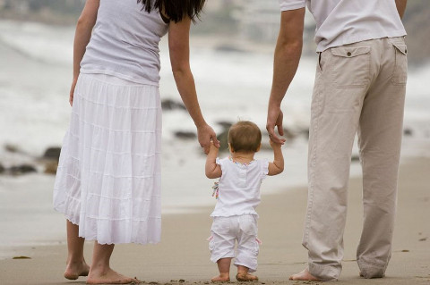 Parents teach child to walk