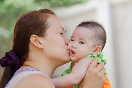 mother kissing baby