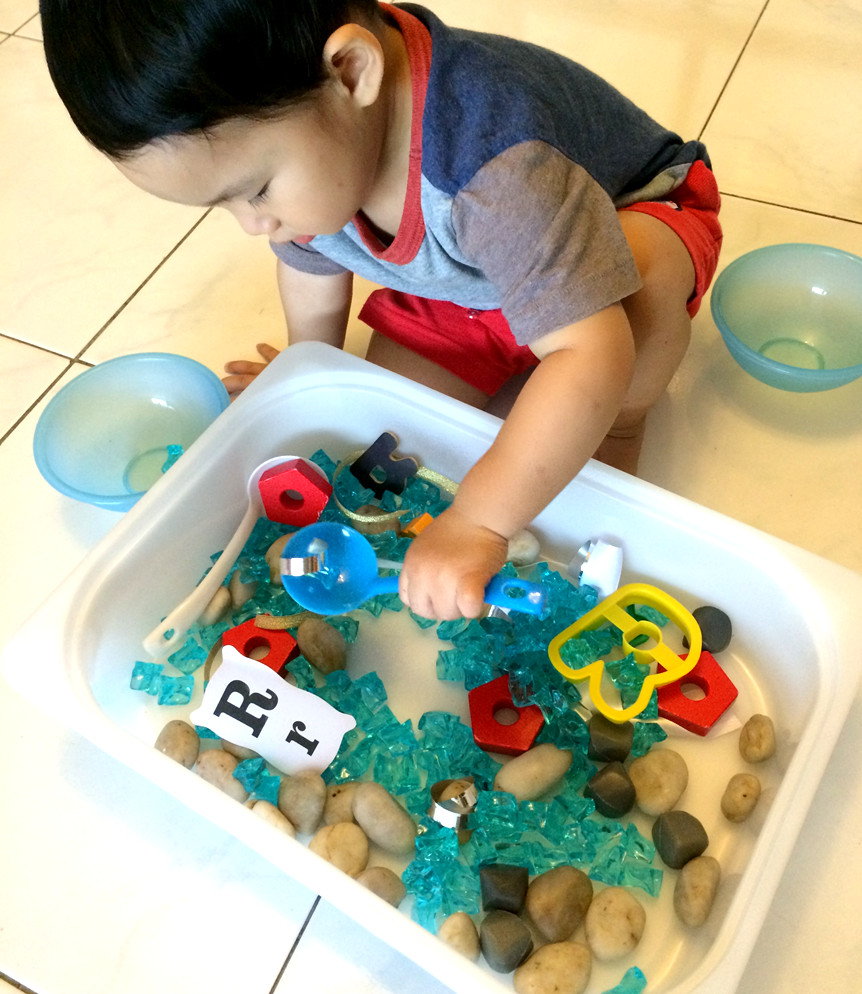 child exploring sensory bin