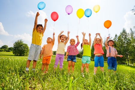 Happy kids flying balloons