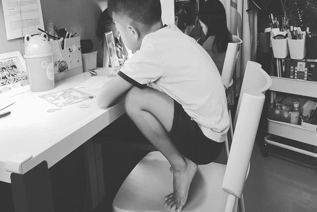 Child squatting at desk