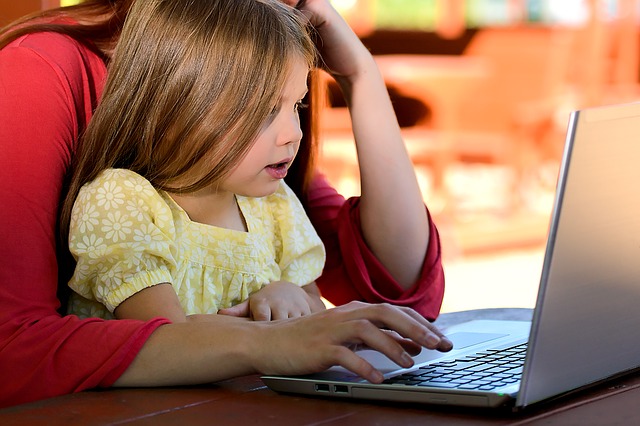 child and parent using laptop