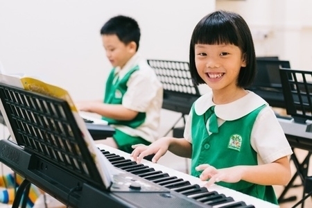 Kinderland student playing piano